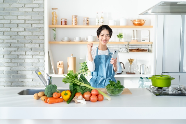 キッチンに立つ女性と野菜