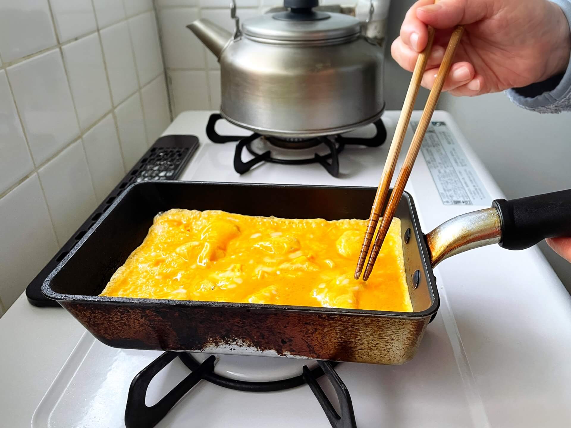 家政婦スタッフがキッチンで美味しそうな卵焼きを作っている写真