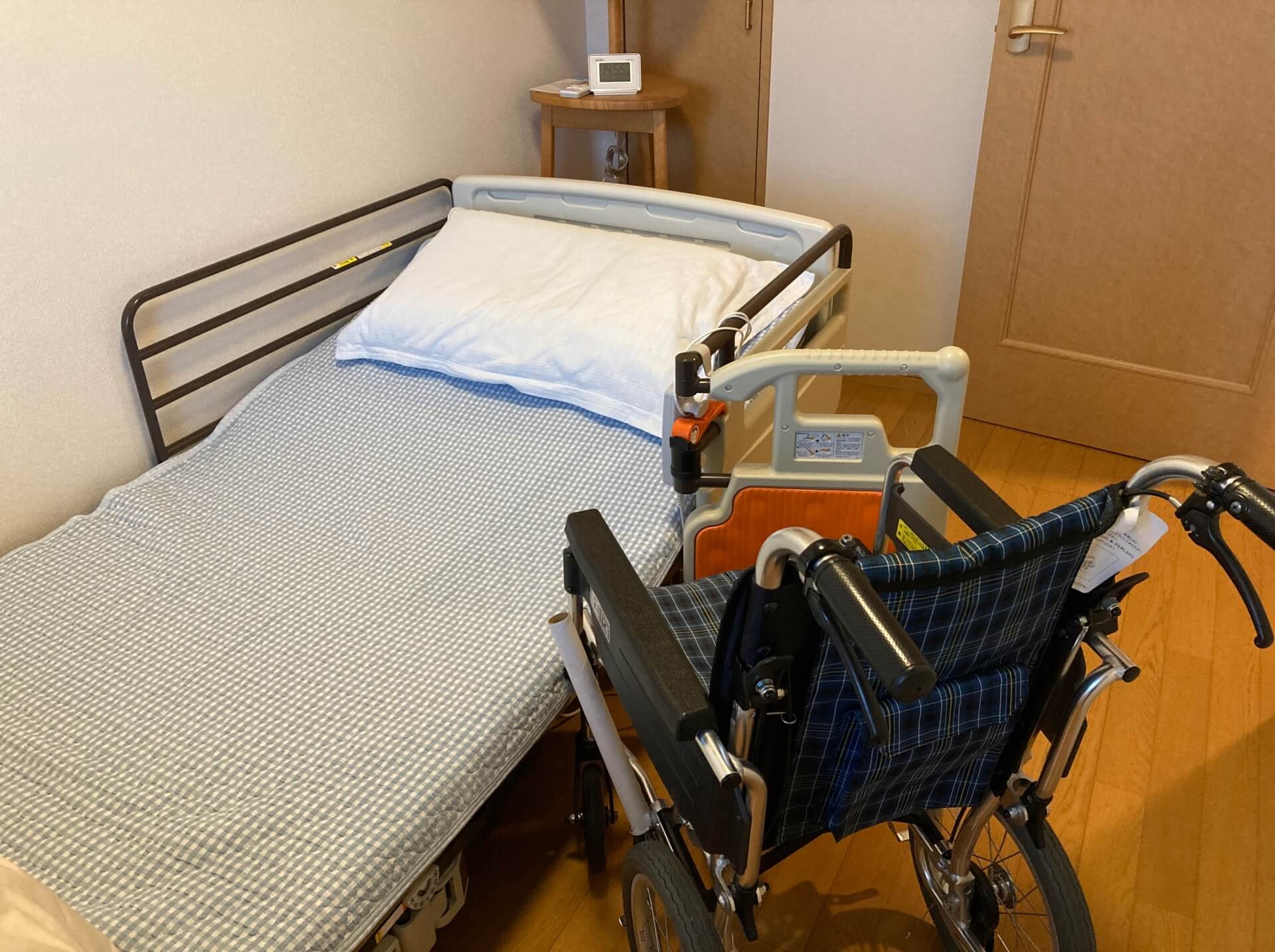 自動昇降機能付きの多機能電動ベッドと、車椅子のある部屋の写真